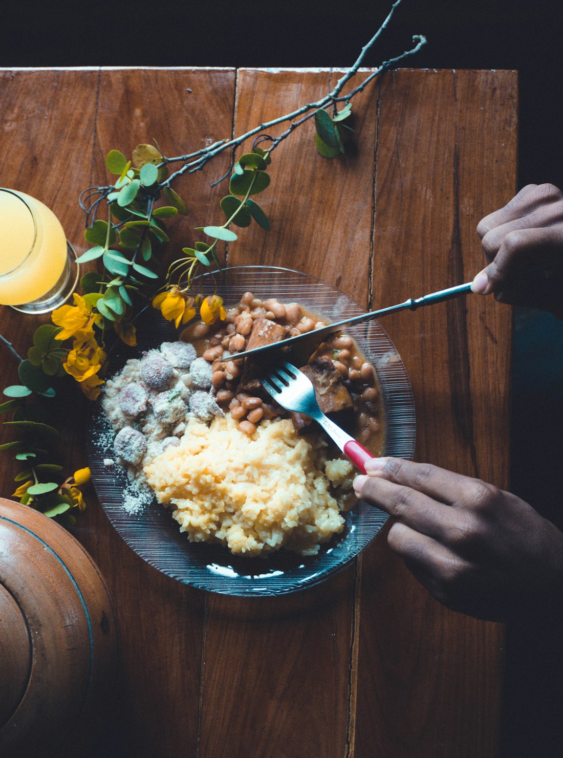 Prato de almoço com arroz, feijão e carne sobre mesa de madeira